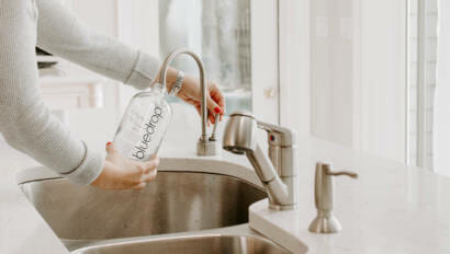 A person using their home drinking water filtration system from bluedrop water.
